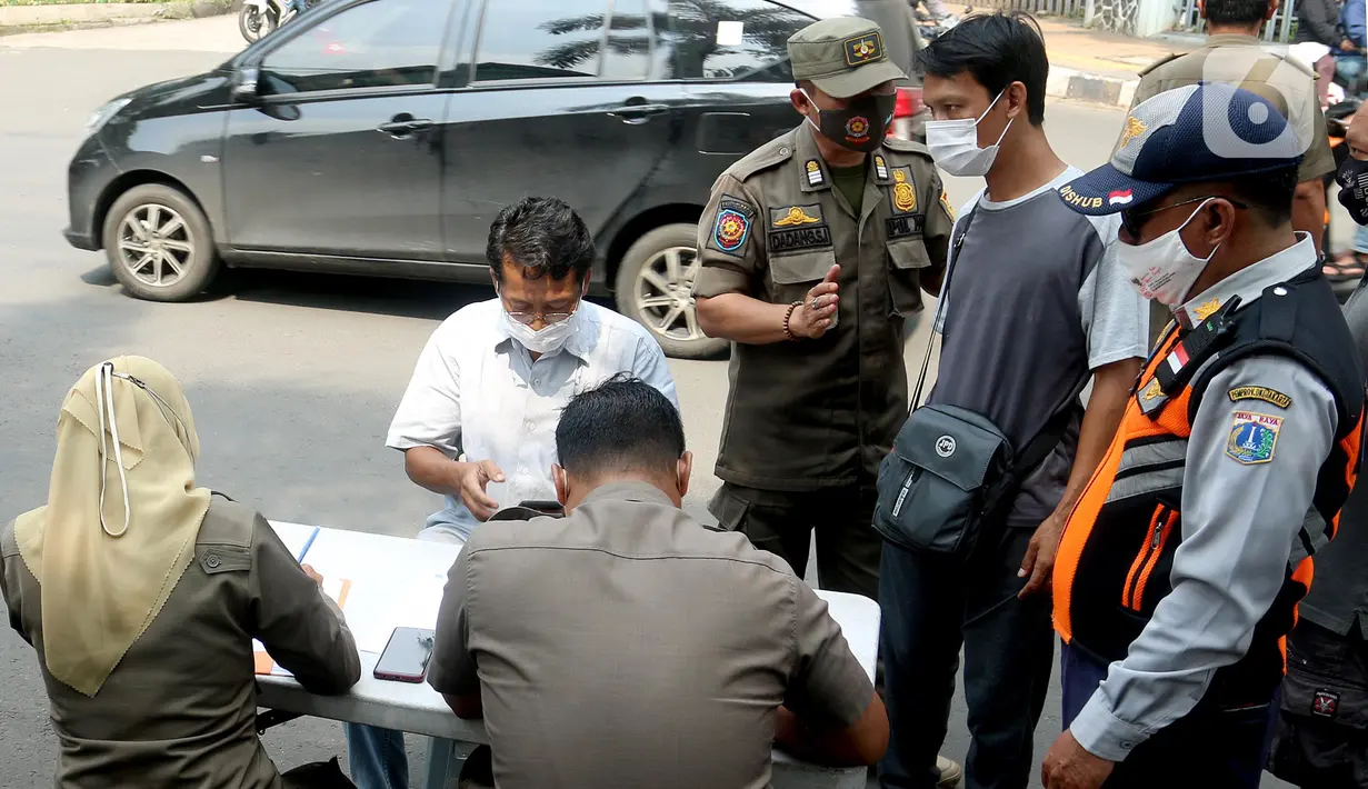 Petugas mendata warga saat operasi tertib masker dalam rangka penerapan protokol kesehatan COVID-19 di Jalan Fatmawati, Jakarta, Kamis (10/3/2022). Pelanggar disanksi kerja sosial menyapu jalan atau denda Rp 250 ribu dan menandatangani surat pernyataan tak mengulangi. (merdeka.com/Arie Basuki)