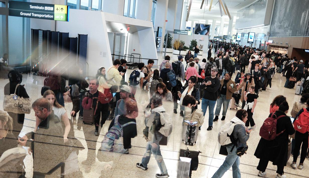 Sebelumnya, penghentian sebagian operasional pemerintah Amerika Serikat atau government shutdown berdampak besar terhadap layanan bandara. Tampak dalam foto, antrean para penumpang untuk melewati pemeriksaan keamanan di Bandara LaGuardia, New York pada Minggu 22 Maret 2026. (CHARLY TRIBALLEAU/AFP)
