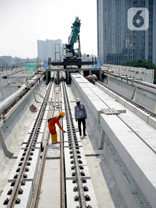Pekerja mengecek perlintasan LRT di jembatan bentang panjang Dukuh Atas, Jakarta, Rabu (11/11/2020). Jembatan bentang panjang hari ini melakukan pengecoran terakhir panjangnya 128 meter. pekerjaan ini menandai selesainya pengerjaan lintasan atas LRT Jabodebek tahap I. (Liputan6.com/Faizal Fanani)