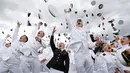 Lulusan US Naval Academy melemparkan topinya ke udara usai upacara kelulusan di Annapolis, Maryland, (26/5). Akademi ini didirikan 10 Oktober 1845, dan sering hanya disebut "Anapolis". (AP Photo / Patrick Semansky)