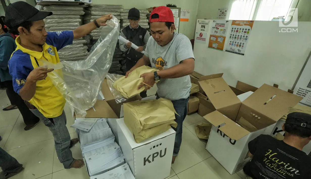 Petugas membungkus kotak suara berisi logistik Pemilu 2019 dengan plastik di Kecamatan Menteng, Jakarta, Senin (15/4). Proses pendistribusian ke tps masing-masing kelurahan diperkirakan akan tuntas sehari sebelum hari pencoblosan pada 17 April 2019. (Liputan6.com/Faizal Fanani)