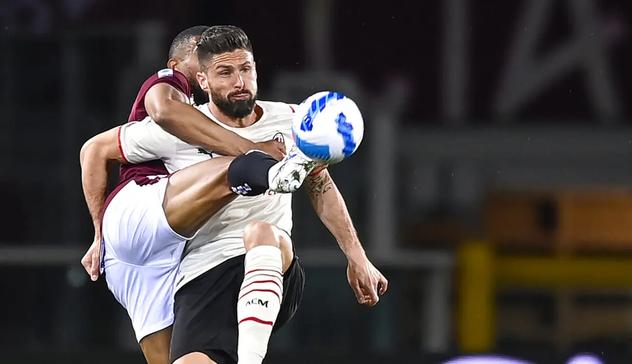 Pemain Torino Bremer (kiri) berebut bola dengan pemain AC Milan Olivier Giroud pada pertandingan sepak bola Serie A di Olimpico Grande Torino Stadium, Turin, Italia, 10 April 2022. Pertandingan berakhir tanpa gol. (Fabio Ferrari/LaPresse via AP)