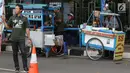 Pedagang kaki lima menjajakan makanan dan minuman di sisi jalan sekitar kawasan Patung Kuda Jakarta, Rabu (5/1/2019). Mereka mencoba peruntungan saat para buruh melakukan aksi perayaan Hari Buruh International atau May Day. (Liputan6.com/Helmi Fithriansyah)