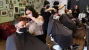 Para pria memotong rambut di barber shop di Melbourne, Australia, Senin (19/10/2020). Warga Kota Melbourne, pada Senin (19/10), akhirnya bisa bernafas lega saat sejumlah pembatasan dilonggarkan setelah menjalani lockdown tahap keempat yang ketat selama sekitar 100 hari. (William WEST/AFP)