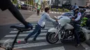 Andika Faizal (19 tahun), mendorong sebuah motor peserta Jogja Bike Rendevouz 2015 dari zebra cross di perempatan Ringroad Utara Condongcatur, Sleman, Yogyakarta, Sabtu (15/08/2015). (foto: Suryo Wibowo)