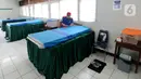 Petugas gugus tugas Covid-19 RW 03 merapikan tempat tidur untuk isolasi mandiri di Gedung Sasana Krida Karang Taruna, Kelurahan Pondok Labu, Jakarta, Selasa (19/1/2020). Penyediaan kamar isolasi ini sebagai antisipasi apabila tempat isolasi mandiri yang disediakan pemerintah penuh. (merdeka.com/Arie