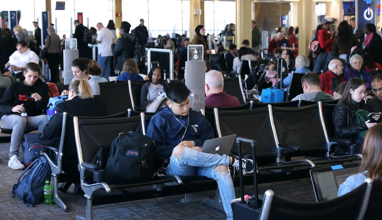 Penumpang menunggu jadwal penerbangan merekadi Bandara Nasional Ronald Reagan, Washington, Rabu (21/11). Tradisi mudik di Amerika dilakukan saat Thanksgiving Day yang jatuh pada Kamis keempat bulan November (CHIP SOMODEVILLA/Getty Images/AFP)