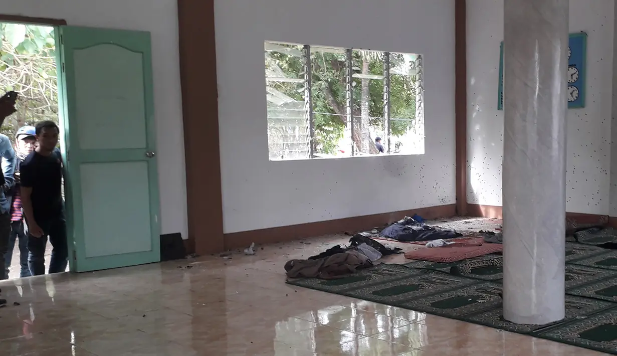 Orang-orang melihat kondisi sebuah masjid setelah serangan granat di Zamboanga, Filipina selatan, Rabu (30/1). Akibat serangan granat tersebut, dua orang tewas dan empat lainnya luka-luka. (Photo by STR / AFP)
