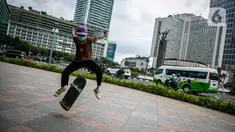 Aksi warga saat bermain skateboard di trotoar Jalan Sudirman-Thamrin, Jakarta, Jumat (5/3/2021). Gubernur DKI Jakarta Anies Baswedan mengizinkan trotoar untuk digunakan sebagai tempat bermain skateboard dengan beberapa kesepakatan. (Liputan6.com/Faizal Fanani)