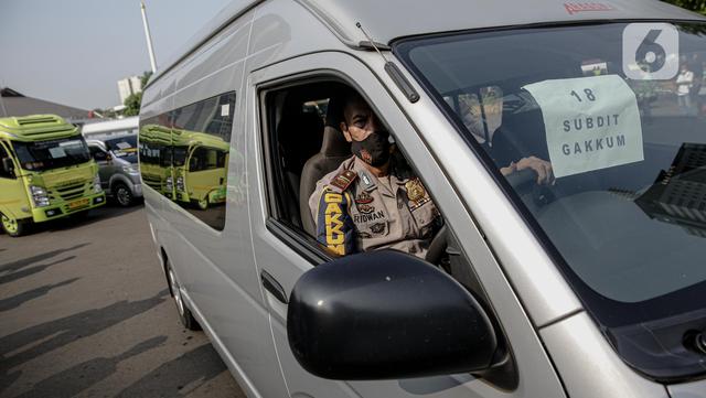 Polisi memeriksa kendaraan travel gelap yang disita jajaran Direktorat Lalu Lintas Polda Metro Jaya, Jakarta, Kamis (29/4/2021). Sebanyak 115 kendaraan travel gelap diamankan karena diduga kuat mengangkut pemudik di tengah masa pengetatan larangan mudik 2021. (Liputan6.com/Faizal Fanani)