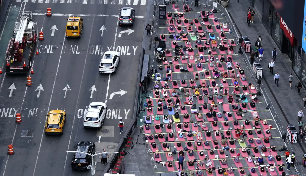 Orang-orang mengikuti acara yoga tahunan untuk merayakan Summer Solstice di Times Square, New York City, Rabu (21/6/2023). (Photo by TIMOTHY A. CLARY / AFP)
