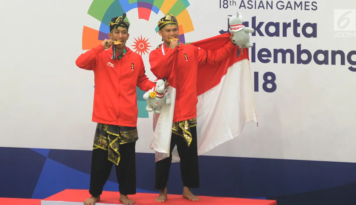 Pesilat Indonesia Yolla Primadona Jumpil dan Hendy berpose usai upacara penyerahan medali nomor seni ganda putra Asian Games 2018 di Padepokan Pencak Silat, TMII, Senin (27/8). Yolla dan Hendy menyabet medali emas dengan skor 580 (Merdeka.com/Arie Basuki)