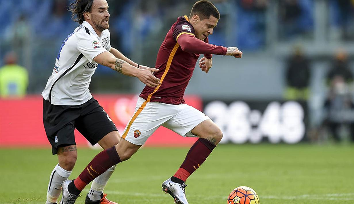 Pemain AS Roma, Juan Iturbe, berusaha melewati pemain Atalanta, Cristian Raimondi  pada laga Serie A di Stadion Olimpico, Italia, Minggu (29/11/2015). (AFP Photo/Andreas Solaro)