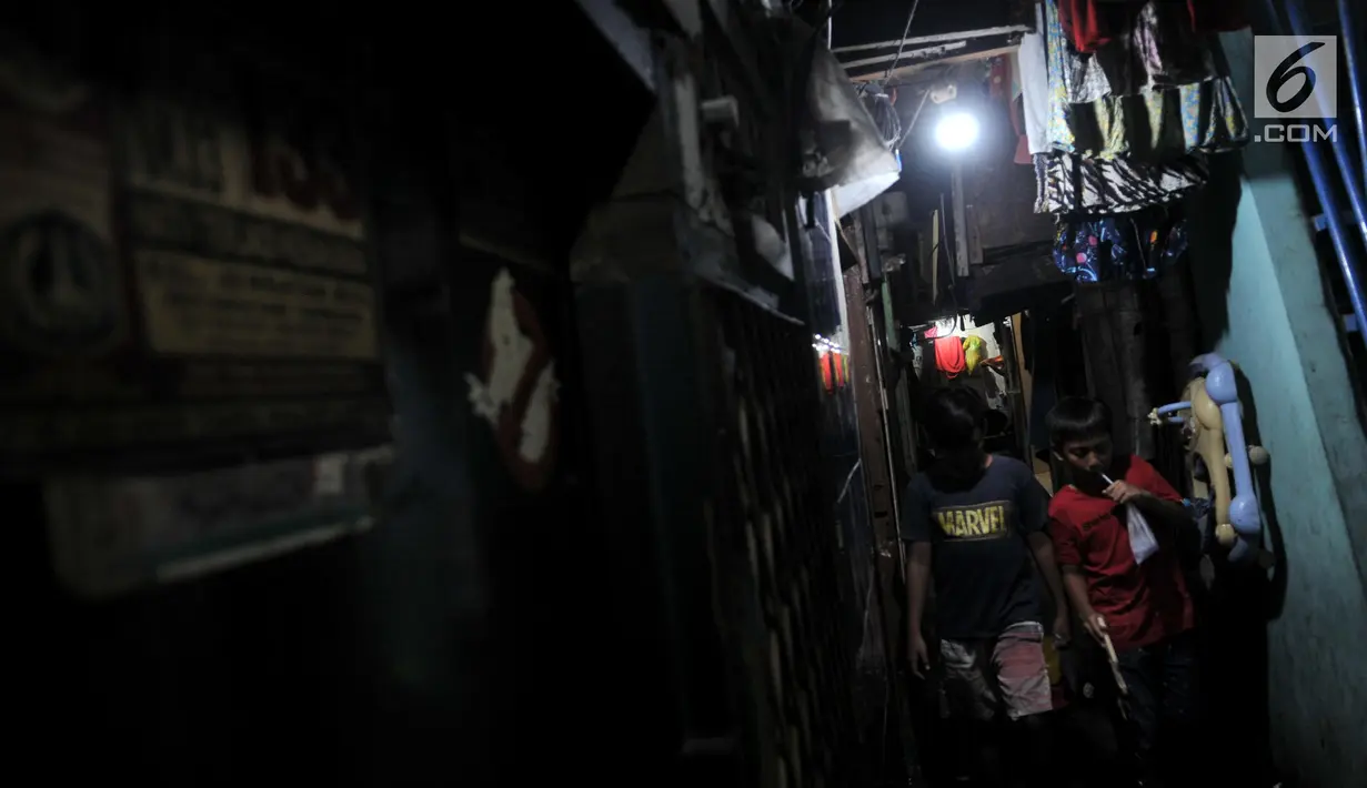 Anak-anak berjalan di Gang Venus, Kelurahan Jembatan Besi, Kecamatan Tambora, Jakarta, Kamis (5/9/2019). Penggunaan listrik berlebihan akibat minimnya cahaya matahari yang masuk ke Gang Venus dapat memicu terjadinya kebakaran(merdeka.com/Iqbal Nugroho)
