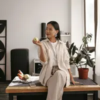 ilustrasi seorang perempuan tersenyum di ruang kantor/copyright freepik.com/lookstudio