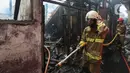 Petugas pemadam kebakaran melakukan proses pendinginan pada permukiman penduduk yang terbakar di Jalan Masjid Alhuda atau depan Stasiun Kebayoran Lama RT 05/01, Jakarta Selatan, Selasa (24/5/2022). Petugas pun mengerahkan 27 unit mobil pemadam kebakaran dari Sudin Damkar Jakarta Selatan ke lokasi kejadian. (Liputan6.com/Johan Tallo)