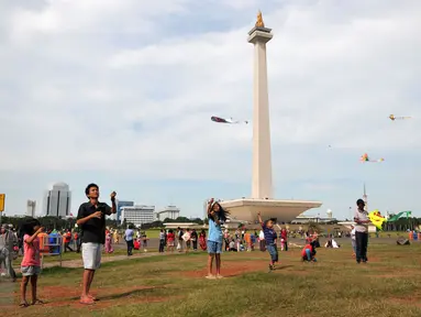 Sejumlah pengunjung bermain layang-layang di kawasan Monas, Jakarta, Sabtu (26/12/2015). Libur Natal dimanfaatkan sejumlah warga untuk berwisata ke tempat yang menjadi ikon Jakarta tersebut. (Liputan6.com/Yoppy Renato)