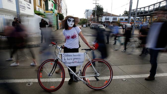 Seorang mahasiswa menggunakan topeng saat menggelar aksi protes menuntut peningkatan anggaran pendidikan di Bogota, Kolombia, Rabu (31/10). (AP Photo/Fernando Vergara)