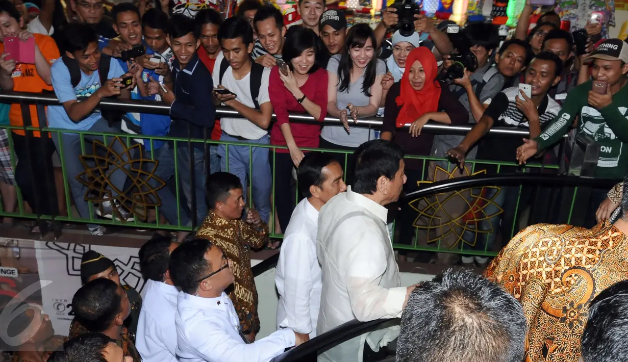 Warga berdesakan menyambut Presiden RI Joko Widodo dan Presiden Republik Filipina ‎Rodrigo Roa Duterte saat meninjau Pasar Blok A Tanah Abang Jakarta, Jumat (9/9). Ini kunjungan kenegaraan pertama Duterte. (Liputan6.com/Helmi Fithriansyah)