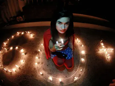 Seorang gadis yang berkostum ala Wonder Woman berpose dalam aksi Global Earth Hour di Gorontalo (ANTARA FOTO/Adiwinata Solihin)