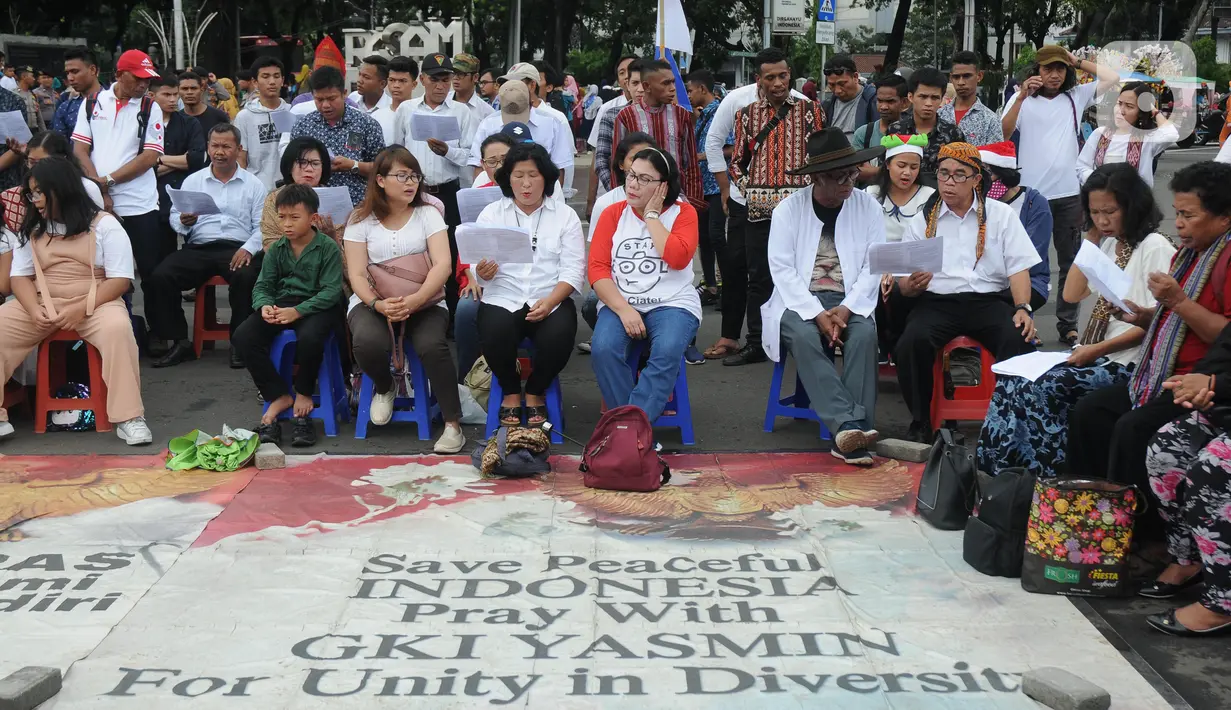 Jemaat dari GKI Yasmin Bogor dan HKBP Filadelfia Bekasi bersiap melaksanakan misa Natal di Simpang Barat Laut Monas atau depan Istana Negara, Jakarta, Rabu (25/12/2019). Ini adalah misa natal kedelapan yang digelar jemaat dua gereja tersebut. (Liputan6.com/Helmi Fithriansyah)