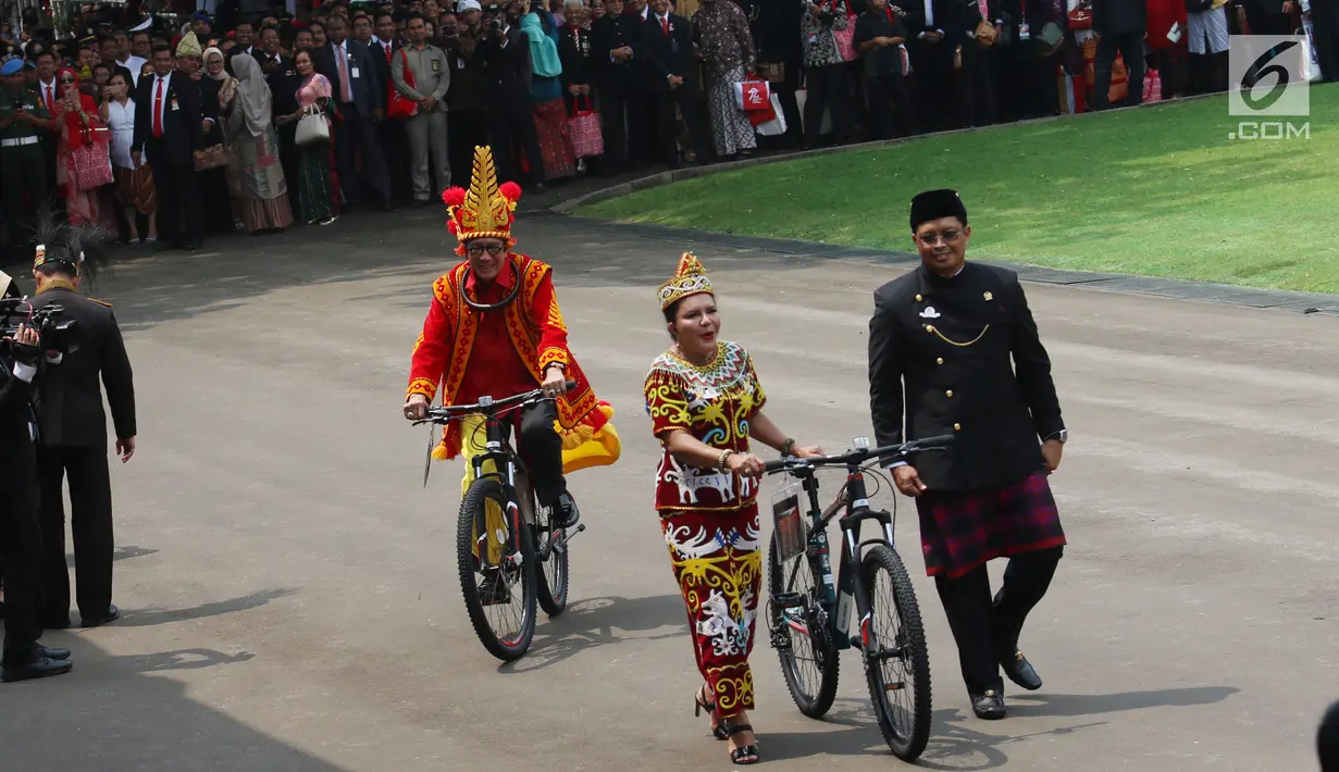Istri Wakil Ketua MPR Aganti Sulie Mahyuddin membawa hadiah sepeda pemberian dari Presiden Jokowi usai peringatan HUT RI ke 72 di Istana Merdeka, Jakarta, Kamis (17/8). Aganti mengenakan kostum adat Dayak. (Liputan6.com/Pool)
