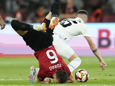 Gelandang Osasuna, Lucas Torro jatuh di sebelah gelandang Real Madrid Federico Valverde pada final Copa del Rey 2022/2023 di La Cartuja, Minggu (7/5/2023) dini hari WIB. (AP Photo/Jose Breton)