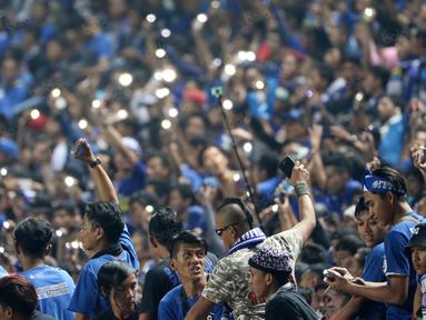 Aksi Bobotoh menyalakan lampu saat mendukung timnya melawan Persija Jakarta pada Torabika SC 2016 di Stadion Gelora Bandung Lauta Api, Bandung, Sabtu (16/7/2016). (Bola.com/Nicklas Hanoatubun)