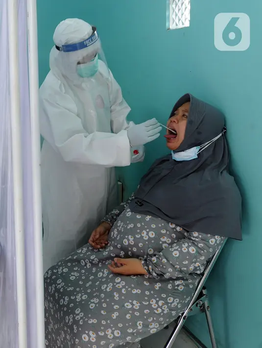 Paramedis melakukan swab test PCR kepada warga di Puskesmas Kramat Jati, Jakarta Timur, Rabu (13/1/2020). Setiap harinya, Puskesmas Kramat Jati menyediakan kuota 300 swab test PCR  secara gratis untuk memutus mata rantai penyebaran COVID-19. (merdeka.com/Arie Basuki)