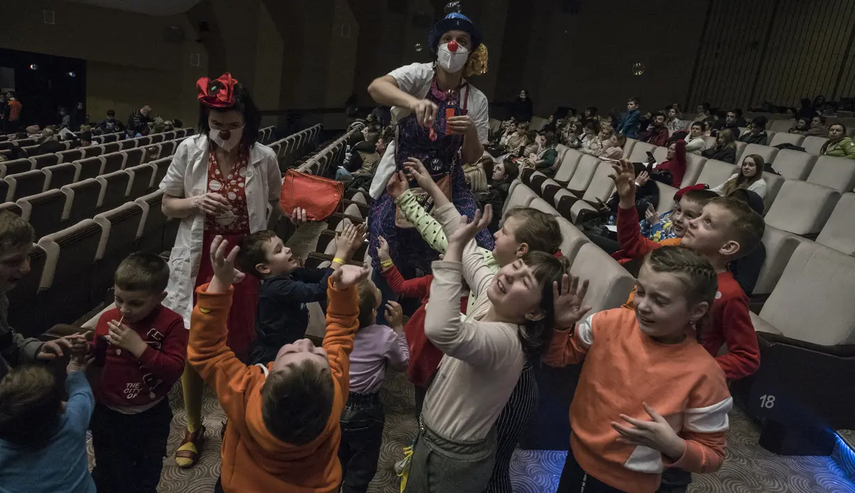 Para badut bermain dengan anak-anak pengungsi Ukraina di pusat bantuan regional di Pusat Kongres Praha di Praha, Republik Ceko (7/3/2022). Meskipun Ceko tidak berbatasan langsung dengan Ukraina, pengungsi dari Ukraina kini mulai berdatangan ke Negara itu. (AFP/Michal Cizek)