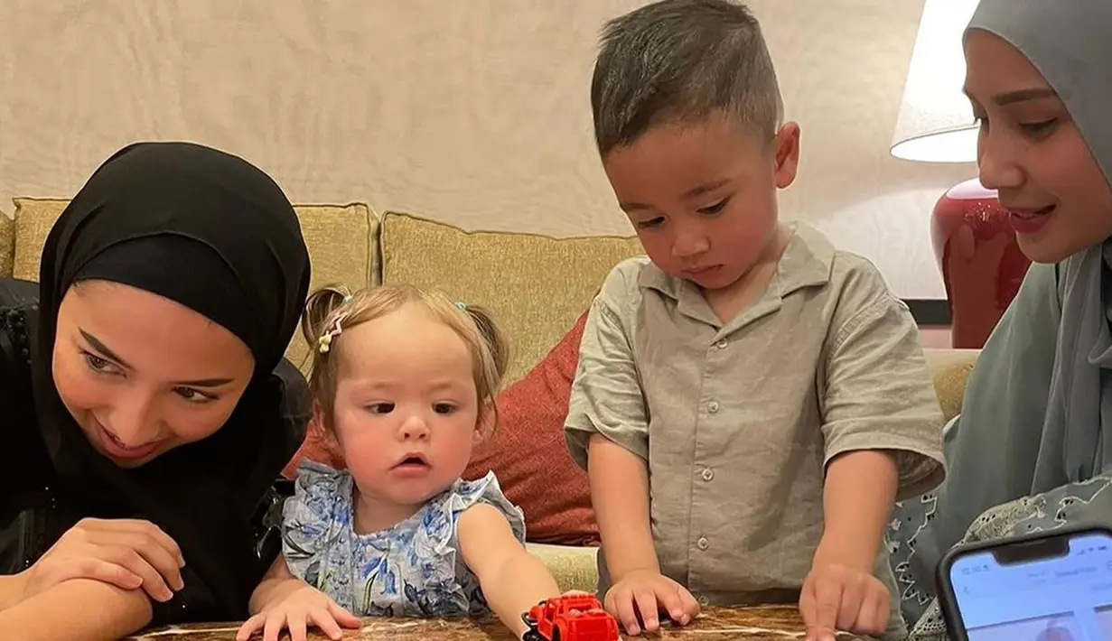 Rayyanza tampak mengajak Kamari bermain mobil-mobilan bersama. Nagita Slavina dan Jennifer Coppen pun kompak menjaga anak mereka. Keduanya cantik berhijab. Nagita tampak mengenakan abaya hijau, sementara Jennifer memakai abaya serba hitam.(Liputan6.com/IG/@raffinagita1717)