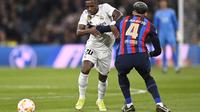 Bek Barcelona, Ronald Araujo mencoba menghadang winger Real Madrid, Vinicius Junior pada leg pertama semifinal Copa Del Rey, 2 Maret 2023. (AFP/Oscar Del Pozo)