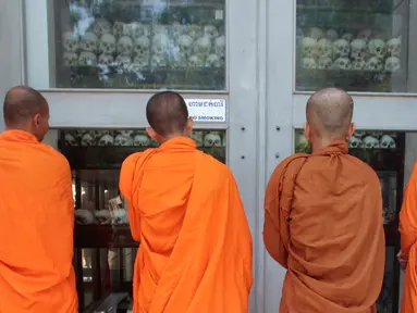 Biksu berdoa di depan stupa yang berisi ratusan tengkorak manusia dan tulang korban rezim Khmer Merah di Choeung Ek memorial, Kamboja (17/4). Mereka berdoa untuk memperingati 42 tahun jatuhnya rezim Khmer Merah pimpinan Pol Pot. (AP Photo/Heng Sinith)