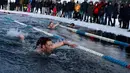Peserta wanita mengikuti kompetisi renang musim dingin tahunan dengan air es beku di Trakai, Lituania (24/2). Para peserta tetap antusias mengikuti lomba walaupun dengan suhu di luar hingga minus 12 derajat Celcius. (AFP Photo/Petras Malukas)