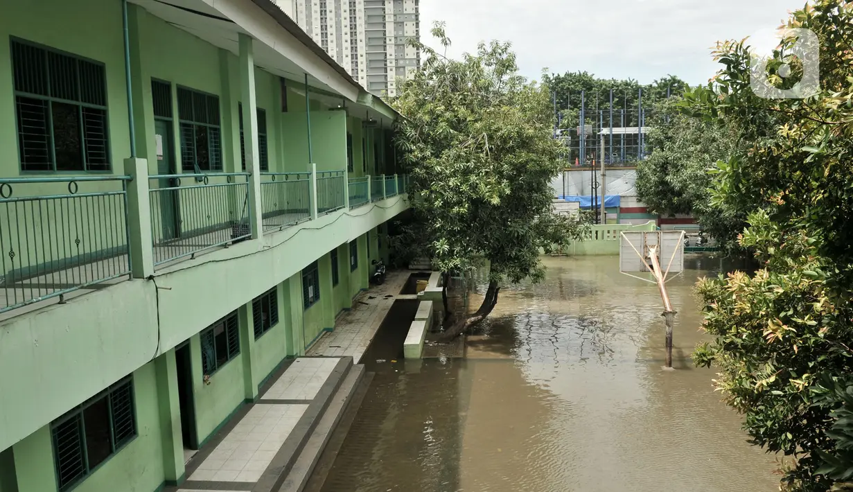 Kondisi banjir yang masih menggenangi gedung Madrasah Tsanawiyah (MTs) Nur Attaqwa, Pegangsaan Dua, Kelapa Gading, Jakarta Utara, Senin (24/2/2020). Banjir yang terjadi sejak Minggu (23/2) kemarin mengakibatkan kegiatan belajar di MTs itu terpaksa diliburkan sementara. (merdeka.com/Iqbal S Nugroho)