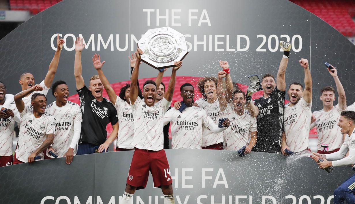Striker Arsenal, Pierre-Emerick Aubameyang, mengangkat trofi juara Community Shield usai menaklukkan Liverpool di Stadion Wembley, Sabtu (29/8/2020). Arsenal menang adu penalti dengan skor 5-4. (Andrew Couldridge/Pool via AP)