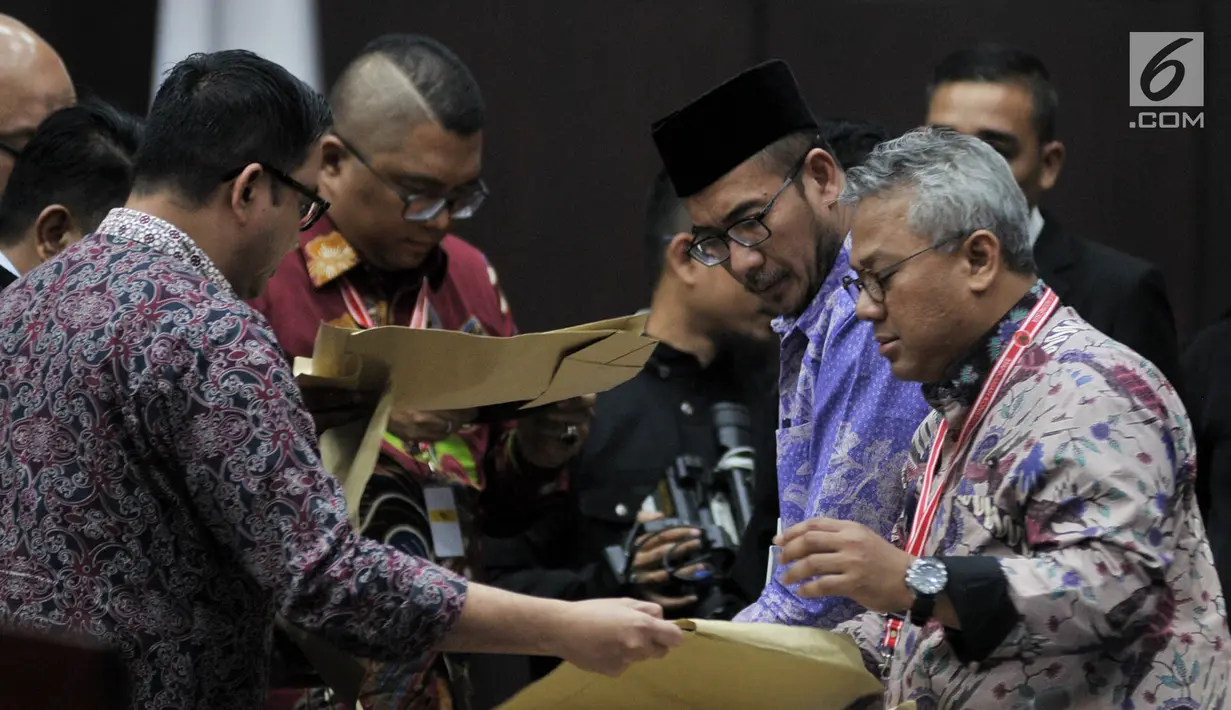 Pihak KPU sebagai Termohon memeriksa barang bukti berupa amplop yang diserahkan oleh saksi fakta Beti Kristiana kepada majelis hakim dalam sidang sengketa Pilpres 2019 di MK, Jakarta, Rabu (19/6/2019). (merdeka.com/Iqbal Nugroho)