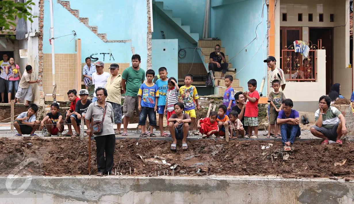 Warga menyaksikan saat petugas membongkar bangunan di bantaran Sungai Ciliwung, Bukit Duri, Jakarta, Selasa (12/1). Pemprov DKI melakukan pembongkaran terhadap sejumlah bangunan terkait proyek normalisasi Sungai Ciliwung. (Liputan6.com/ Immanuel Antonius)
