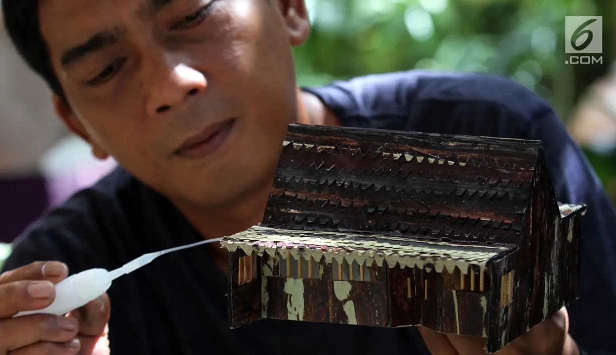 Perajin, Inoe Farhand menyelesaikan pembuatan miniatur jam dari pelepah pisang di Pamulang, Tangsel, Kamis (10/1). Dalam sehari Inoe mampu menyelesaikan dua buah kerajinan tangan seperti miniatur becak, mobil VW dan Kapal phinisi (Merdeka.com/Arie Basuki)