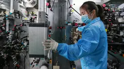 Karyawan wanita mengecek mesin saat bekerja di sebuah pabrik baterai di Huaibei di provinsi Anhui timur China (6/3). Industri listrik berkembang pesat dan saat ini berada di peringkat ketiga di China timur. (AFP Photo/STR)