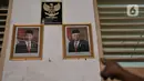 Siswa menunjukkan batas ketinggian banjir yang hampir merendam foto Presiden Jokowi dan Wakil Presiden Maruf Amin di SD-SMP Perguruan Rakyat 2, Kampung Melayu Kecil, Kelurahan Bukit Duri, Kecamatan Tebet, Jakarta Selatan, Senin (6/1/2020). (merdeka.com/Iqbal S. Nugroho)