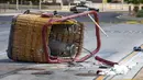 Keranjang balon udara yang jatuh tergeletak di trotoar di Albuquerque, New Mexico, Amerika Serikat, Sabtu (26/6/2021). Polisi mengatakan lima penumpang tewas setelah jatuh di jalan yang ramai. (AP Photo/Andres Leighton)