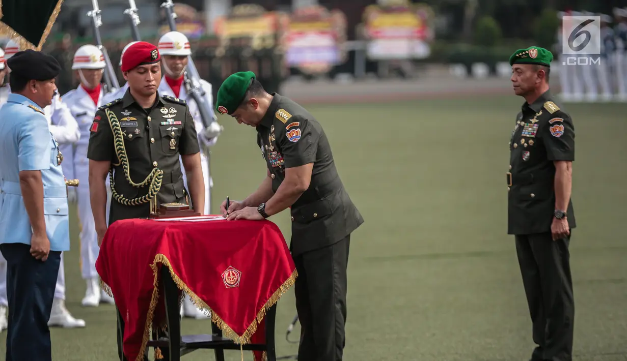 Pejabat baru Kepala Staf TNI Angkatan Darat (KSAD) Jenderal Andika Perkasa disaksikan Panglima TNI Marsekal Hadi Tjahjanto menandatangani berkas serah terima jabatan di Mabes TNI AD, Jakarta, Kamis (29/11). (Liputan6.com/Faizal Fanani)