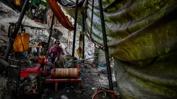 Pekerja mengoperasikan mesin saat melakukan pengeboran di sumur minyak ilegal di Minhla, Myanmar, 10 Maret 2019. Para pekerja dapat mengebor hingga satu kilometer ke dalam tanah. (Ye Aung THU/AFP)