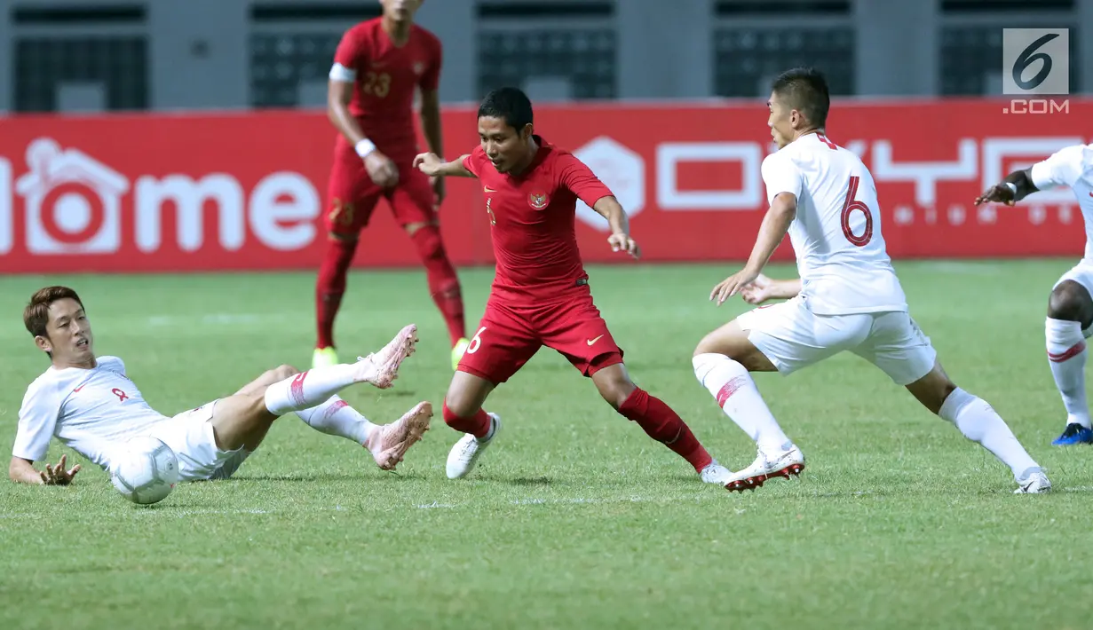 Pemain tengah Timnas Indonesia, Evan Dimas Darmono (tengah) mencoba melewati adangan pemain Hong Kong pada laga uji coba internasional di Stadion Wibawa Mukti, Cikarang, Selasa (16/10). Laga berakhir imbang 1-1. (Liputan6.com/Helmi Fithriansyah)