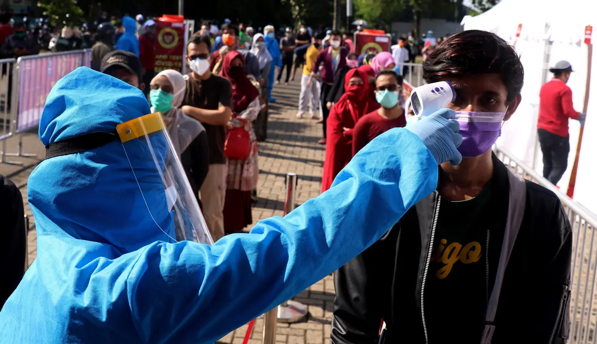 Petugas menggukur suhu warga yang akan mengikuti rapid test massal di Kota Tangerang, Banten, Sabtu (30/5/2020).  Badan Intelijen Negara (BIN) menggelar tes diagnostik cepat (rapid rest) massal kepada warga Ciledug sebagai salah satu upaya pengendalian transmisi COVID-19. (Liputan6.com/Angga Yuniar)