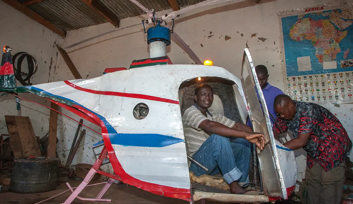 Felix Kambwiri duduk di kokpit helikopter buatannya di garasi rumahnya di Desa Gobede, Malawi, 19 Februari 2016. Helikopter yang dikerjakan sejak empat bulan lalu itu dibuat dari rongsokan besi tua dan fiberglass. (Amos Gumulira/AFP)