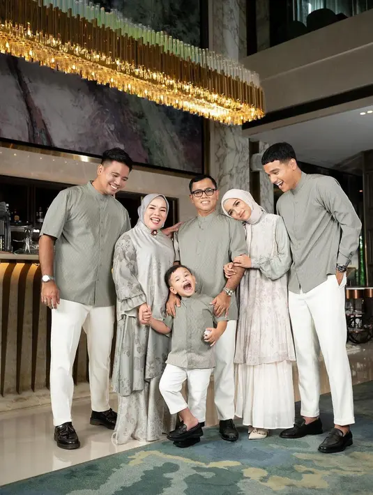 Fuji Utami dan keluarga unggah beberapa outfit baju Lebaran. Salah satunya hijau keabuan yang memberikan kesan adem dan netral [@fuji_an]