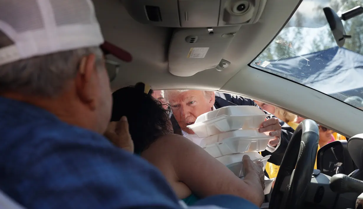 Presiden AS, Donald Trump membagikan makanan kepada korban badai Florence di Temple Baptist Church di New Bern, N.C. (19/9). Badai Florence menewaskan sedikitnya 32 orang. (AP Photo/Evan Vucci)