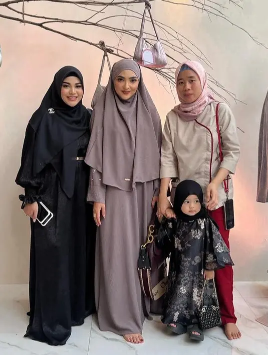 Ashanty tampil dengan khimar dan dress panjang abu-abu. Sedangkan, Aurel mengenakan dress dan kerudung hitam. [@ashanty_ash]